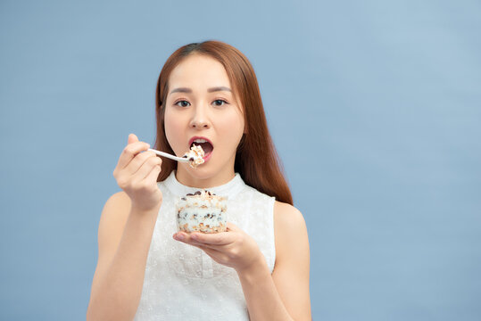 Beautiful Young Woman Eating Fresh Yoghurt, Raisins And Oatmeal For Breakfast.