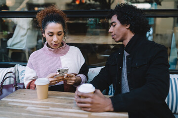 Young friends enjoying coffee in street cafe
