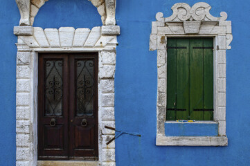Typical italian venetian historic facade of an  old colorful building painted of blue inside the little island of Burano near Venice, Italy