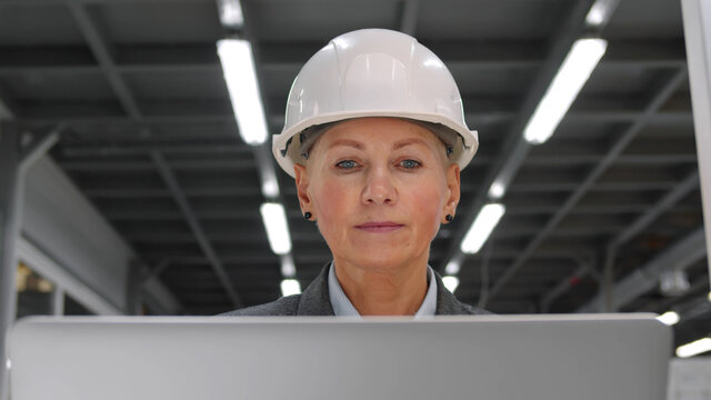 Businesswoman running industrial factory and visiting production workshop using portable computer