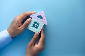  the concept of finance concept , young man holding house in hand 