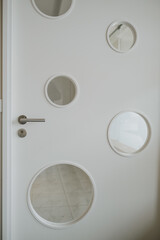 Vertical shot of a white door with glass circles design