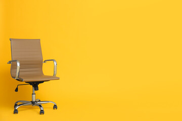 Modern office chair on yellow background. Space for text