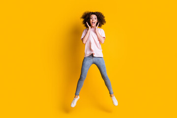 Fototapeta na wymiar Photo portrait full body view of girl with spread legs hands near face open mouth jumping up isolated on vivid yellow colored background