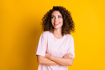 Photo of young curious dreamy girl crossed hands look empty space isolated over yellow color...