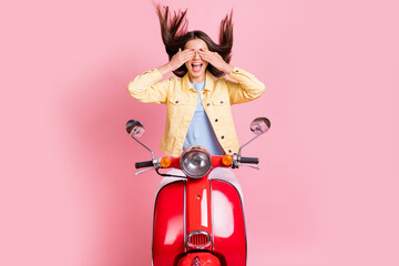 Fototapeta na wymiar Photo of young happy smiling attractive girl woman cover face ride red fly hair motorbike isolated on pink color background