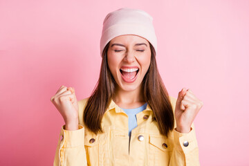 Photo of lucky sweet young lady wear casual outfit headwear arms hands fists closed eyes isolated pink color background