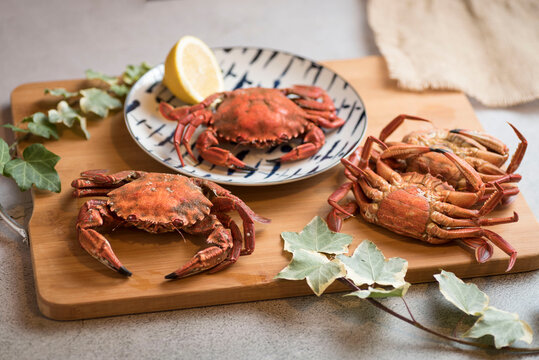 Deliciously cooked crabs on plates with lemons and herbs