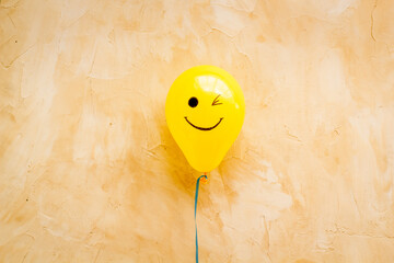 Happiness emotion face on balloon - joy mood background. Top view, copy space
