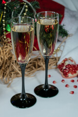 Close-up. Two glasses of champagne. Windrik Christmas background with drinks. Pomegranate fruit in the background.