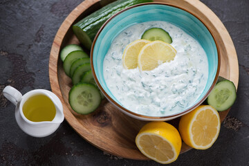 Greek tzatziki or cucumber yogurt sauce, studio shot on a brown stone background, elevated view