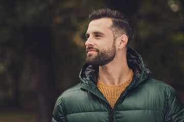 Profile portrait of handsome person look interested far away wearing warm clothing walking outdoors