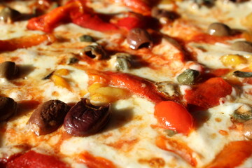 Pizza con formaggio, pomodori, peperoni, capperi e olive