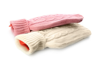 Hot water bottles with knitted covers isolated on white