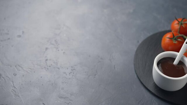 The camera moves along cherry tomatoes and tomato sauce, dark background, space for text