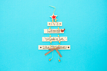Christmas  card, tree with words Its beginning to look a lot  like Christmas  on blue background.