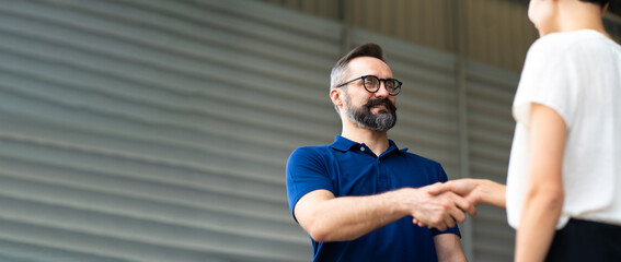 Expertise mechanic shaking hands with satisfied customer and working in automobile repair maintenance station garage. Satisfaction in service