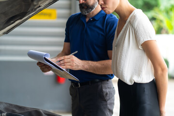 Mechanic man and woman customer check the car condition before delivery. automobile repair maintenance station garage.