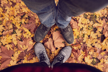 Pies en un parque con hojas de otoño