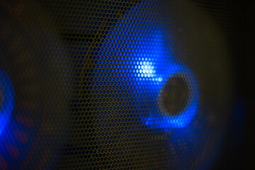 Blue led lighting PC computer cooling fans behind black wire mesh close up shallow depth of field