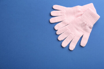 Pair of stylish woolen gloves on blue background, flat lay. Space for text