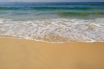 Fototapeta na wymiar Empty wavy beach on the beautiful sunny day