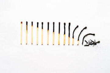 row of burned-out matches over the white background