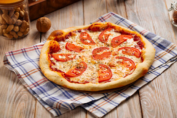 Margherita pizza with tomatoes on the wooden table