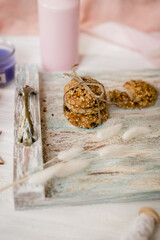 Gray aged tray with pink candle and spikelets with homemade oatmeal cookies wooden background