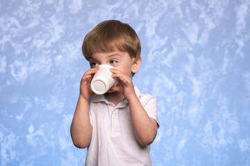 little boy drinks water from a disposable cup of cornstarch. ecologicaly clean. replacing plastic...