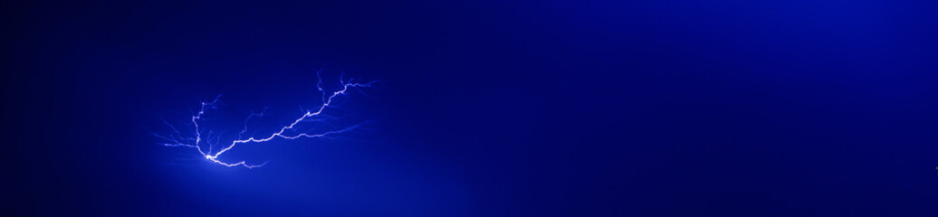 bright yellow lightning on blue dark sky