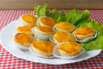 Empada or empadinha is a very popular and traditional snack of Brazilian cuisine, on a white plate on a table covered with a towel