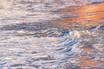 Wave of the sea water at sunset time.