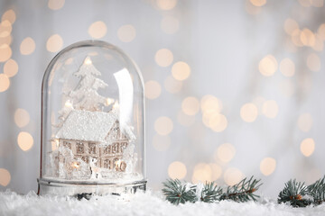 Beautiful snow globe against blurred Christmas lights. Space for text