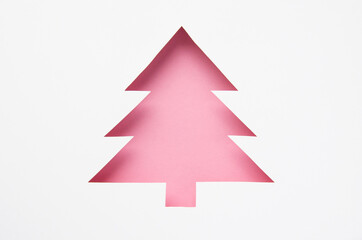 Greeting card with a Christmas tree cut out of paper. Silhouette of a pink fir tree. Happy new year. Merry christmas. 2021