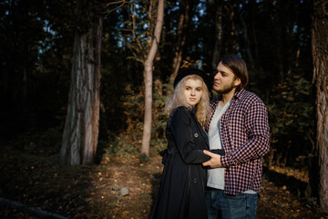 Young couple are hugging and loving each other in autumn park