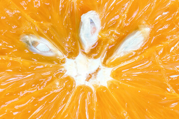 Piece of orange with sweet and sour juicy pulp and seeds close-up. A good source of vitamin C and...