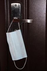 close-up of medical protective mask on the front door handle