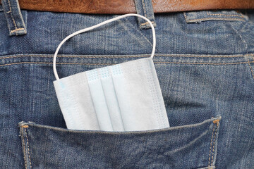 protective medical mask in jeans pocket close-up