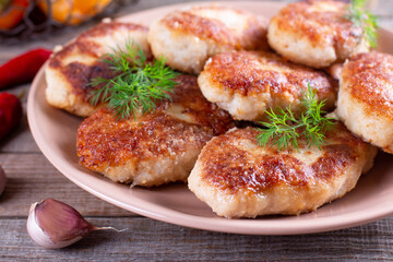 Delicious fish cutlets with dill closeup in a plate on the table. Horizontal