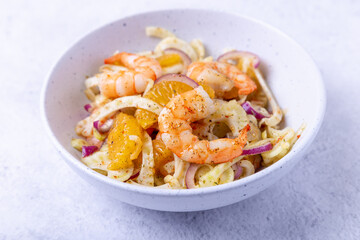Shrimp salad with fennel, orange and red onion. Close-up, selective focus.
