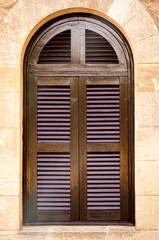 Arched window with closed shutters