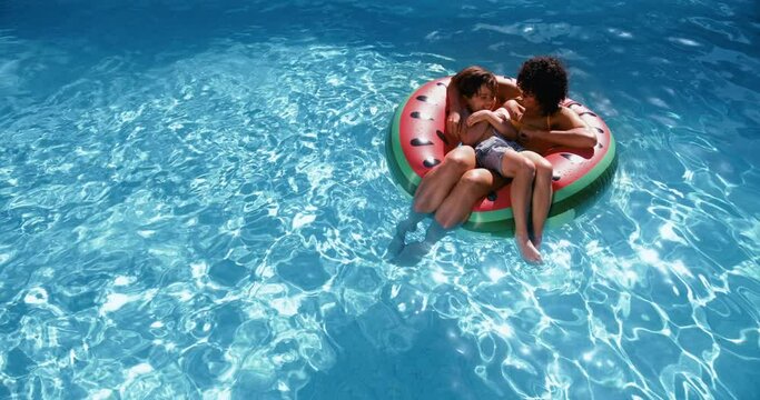 Mother and son floating in swim ring in a pool