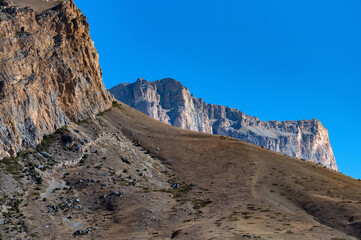 Rocks and dry grass in North Caucasus mountains in autumn on sunny day