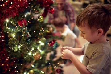 Happy family decorating a Christmas tree at home. Together, New Year, family, celebration