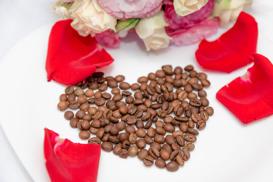 Heart of coffee beans with rose petals