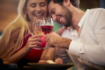 A young couple in love enjoying a drink at Valentine's day celebration at a restaurant. Together, Valentine's day, celebration