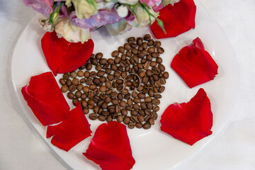 Heart of coffee beans with rose petals