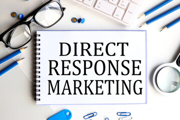 direct response marketing, text on white paper on a light background near glasses and a magnifying glass