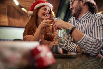 A young couple in love toasting at Xmas celebration at a restaurant. Together, New Year, celebration